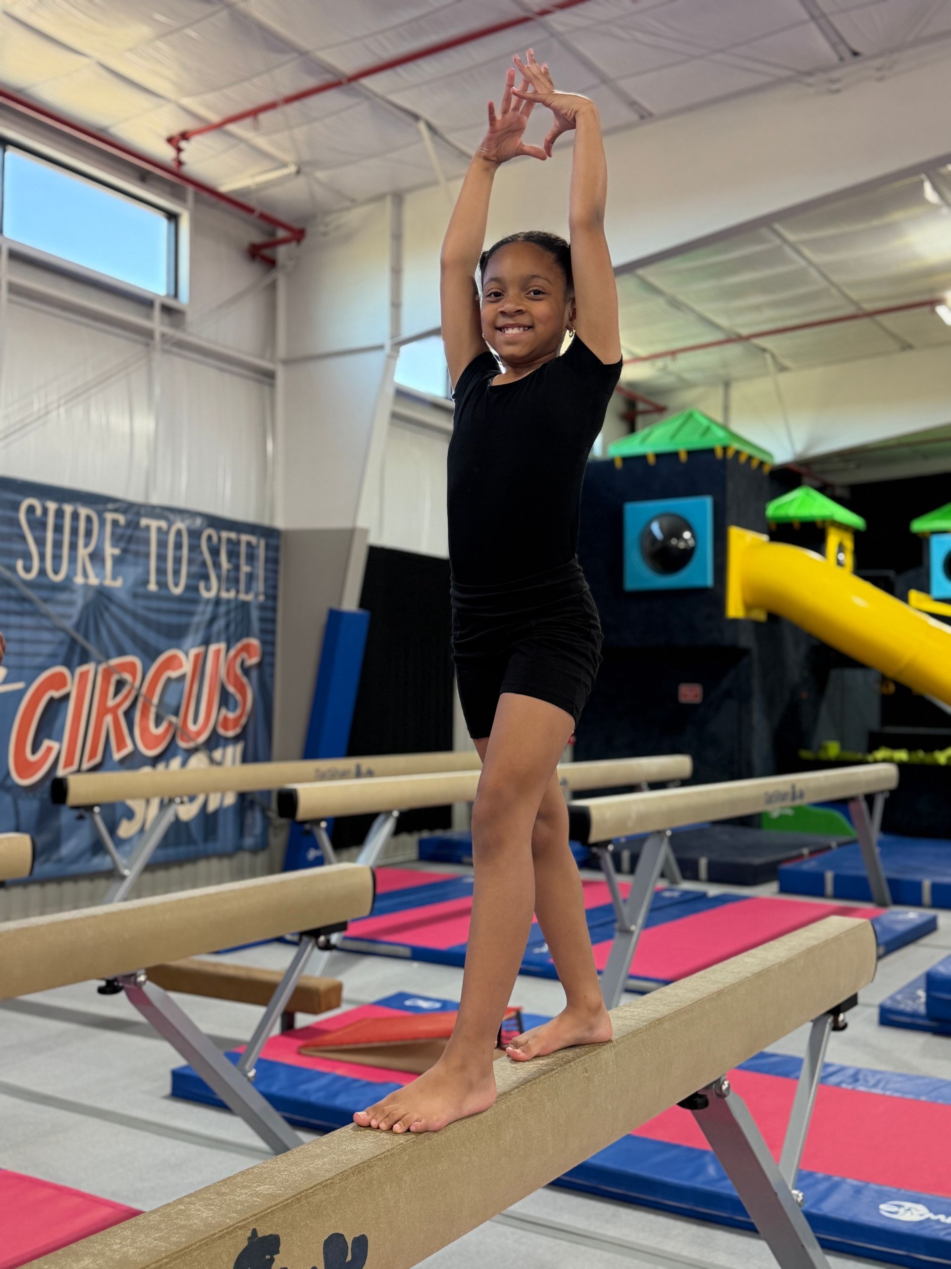 A group of young girls are posing for a picture while sitting on a mat.