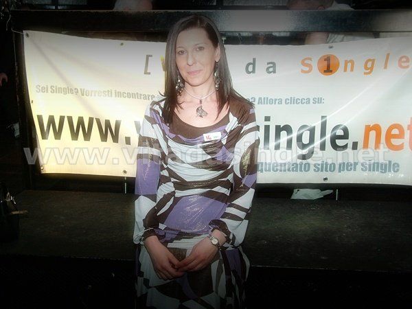 Una donna single seduta davanti a un cartello www.vitadasingle.net