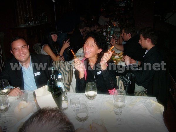 Un gruppo di persone è seduto a un tavolo del Twiga Forte dei Marmi durante una cena Vitadasingle.net