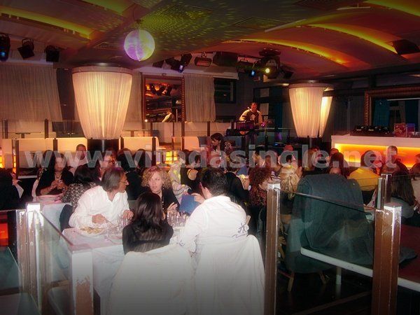 Un gruppo di persone ai tavoli di un ristorante per la cena dei single Vitadasingle.net