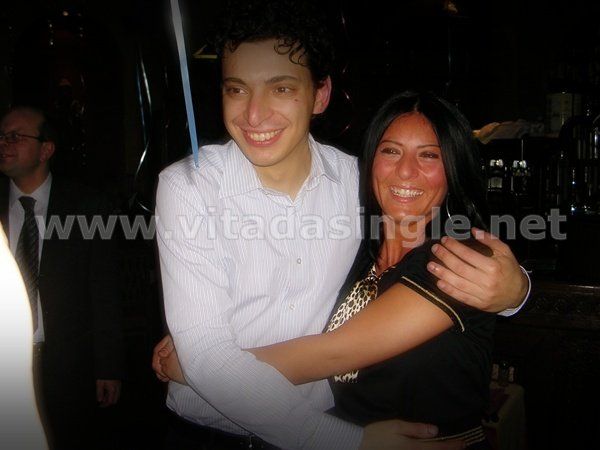 Un uomo single abbraccia una donna con il sito vitadasingle.net sullo sfondo