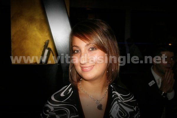 Una donna sorride davanti ad un cartello che dice www.vitadasingle.net