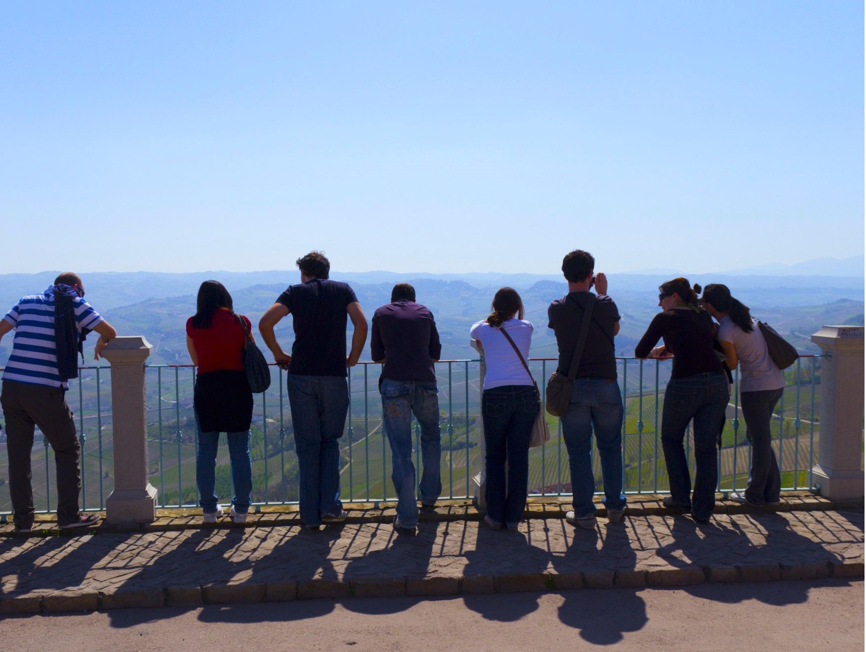 Un gruppo di persone in piedi su un balcone che si affaccia sulle Langhe