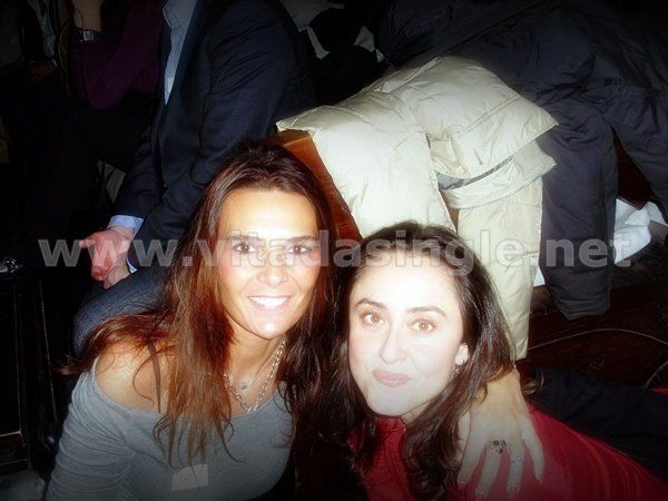 Due donne posano per una foto con il sito www.vidasingle.net sullo sfondo