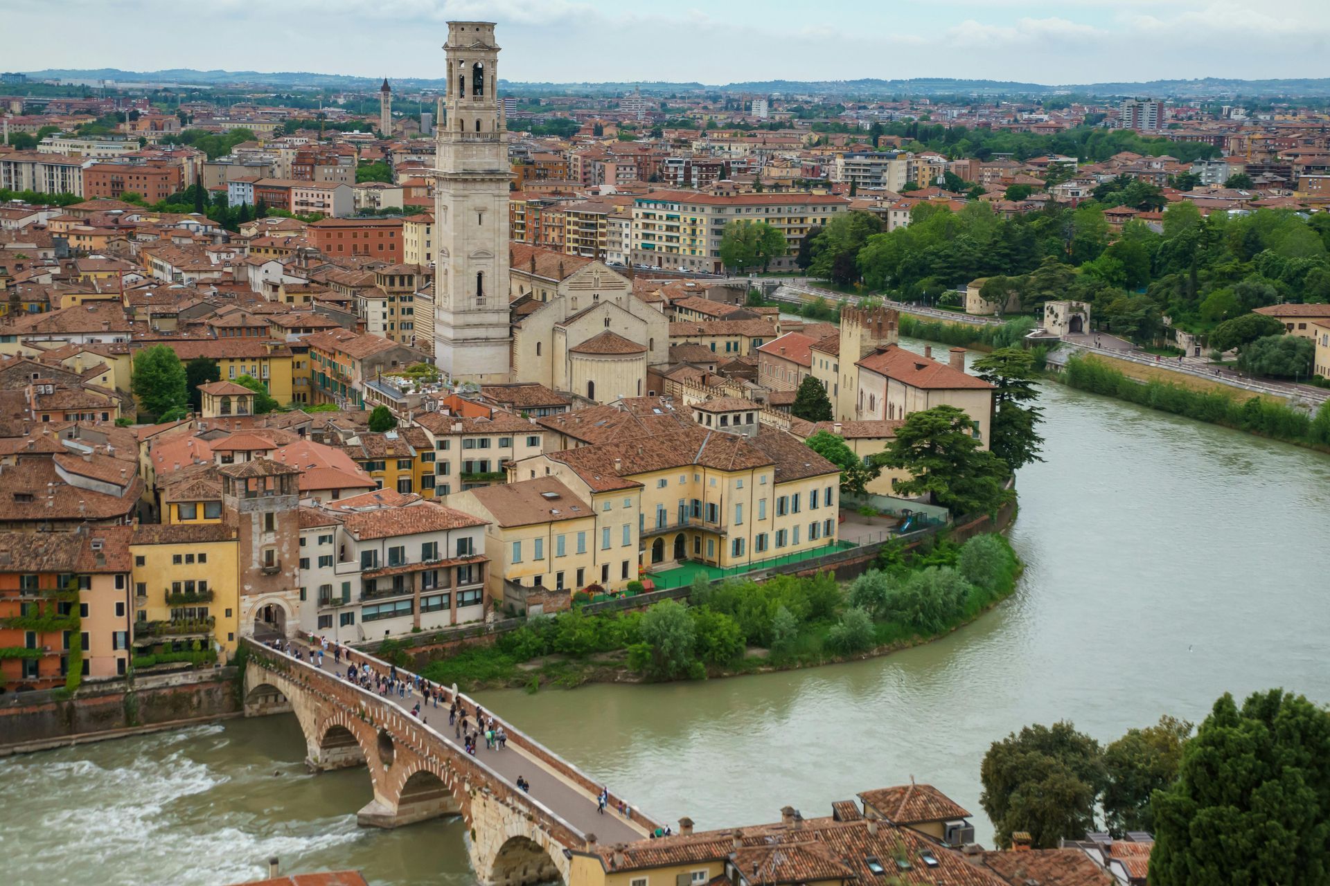 Una vista aerea di Verona con un ponte sopra un fiume.