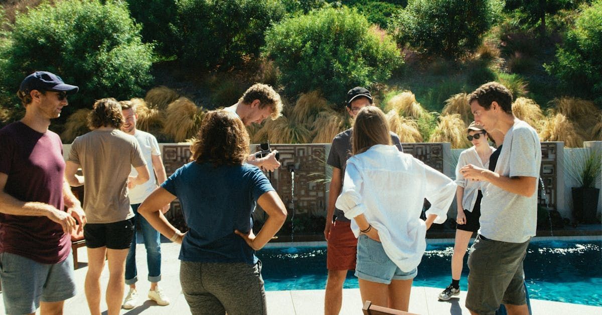 Un gruppo di persone è in piedi intorno a una piscina.