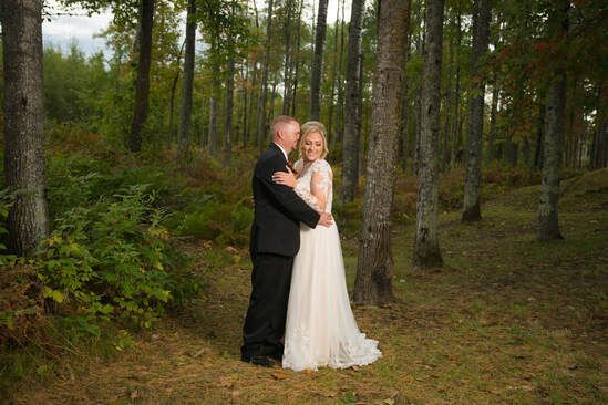 A bride and groom are posing for a picture in the woods.