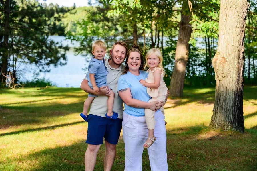 A family is posing for a picture in a park.