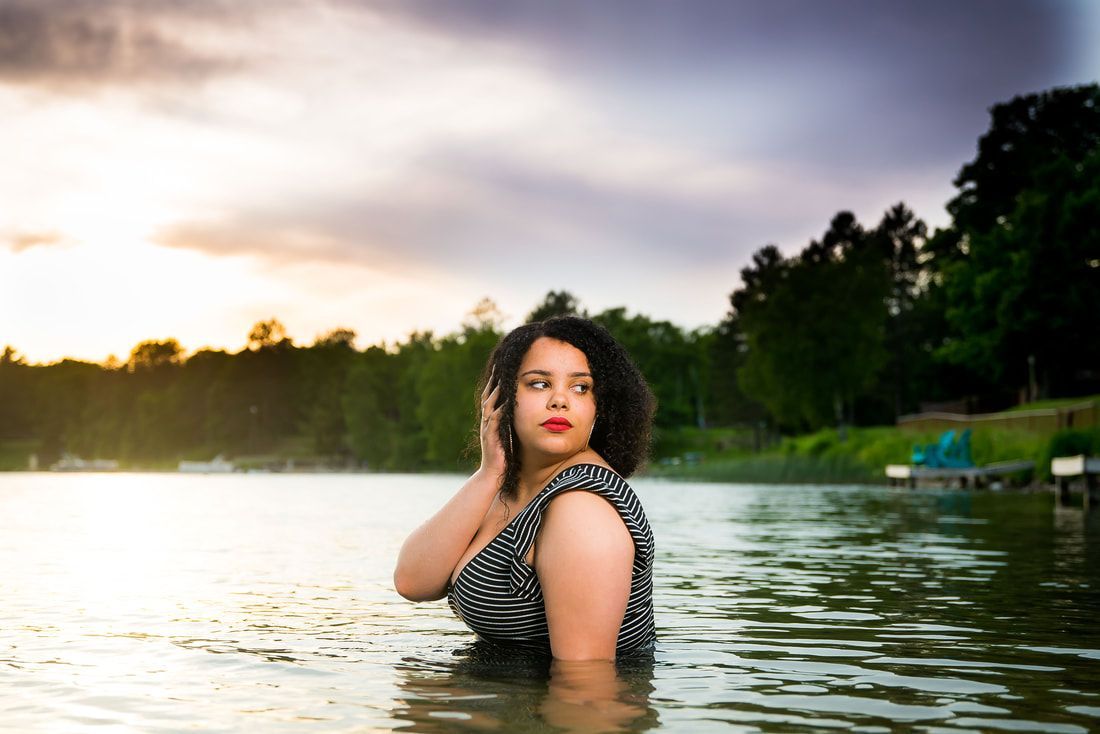 A woman is standing in the middle of a lake.