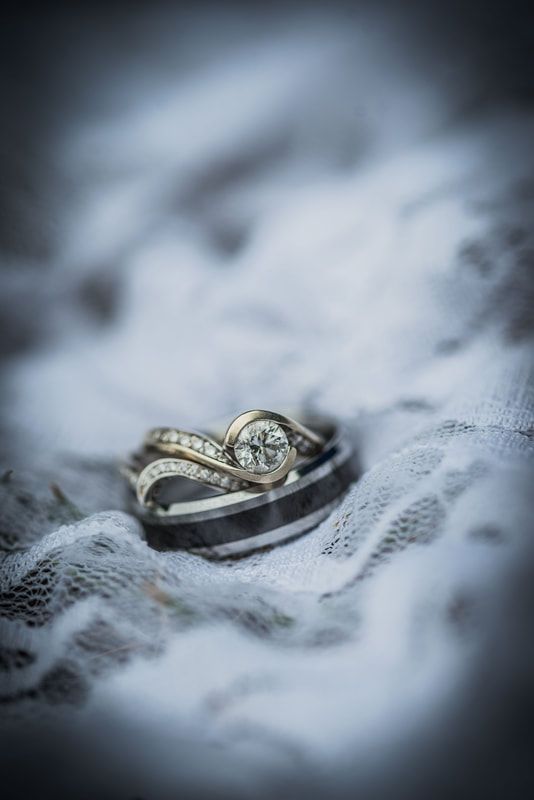 A close up of a wedding ring on a piece of lace.