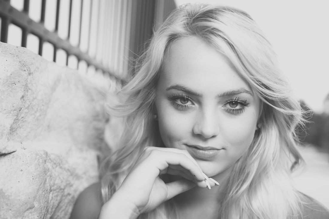 A black and white photo of a woman with her hand on her chin.