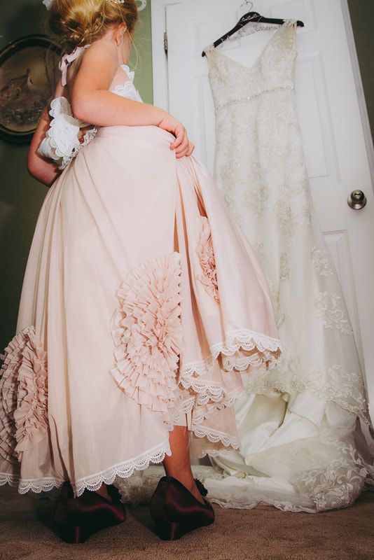 A woman in a wedding dress is standing next to a wedding dress.