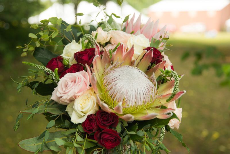 A close up of a bouquet of flowers sitting on top of a table.