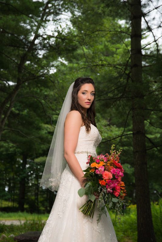 The bride is wearing a veil and holding a bouquet of flowers.