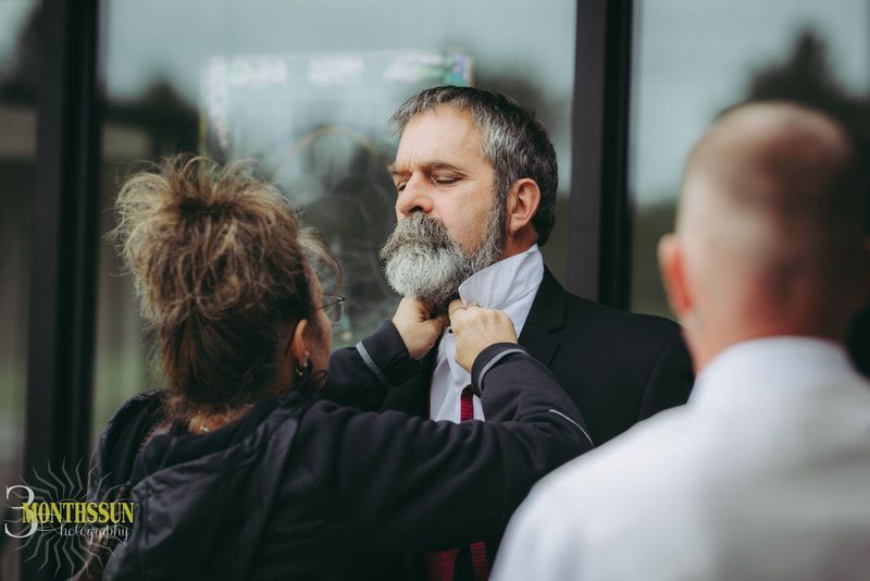 A woman is helping a man with his tie.
