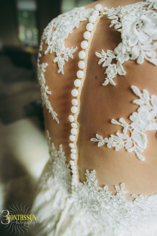 A close up of the back of a bride 's wedding dress.