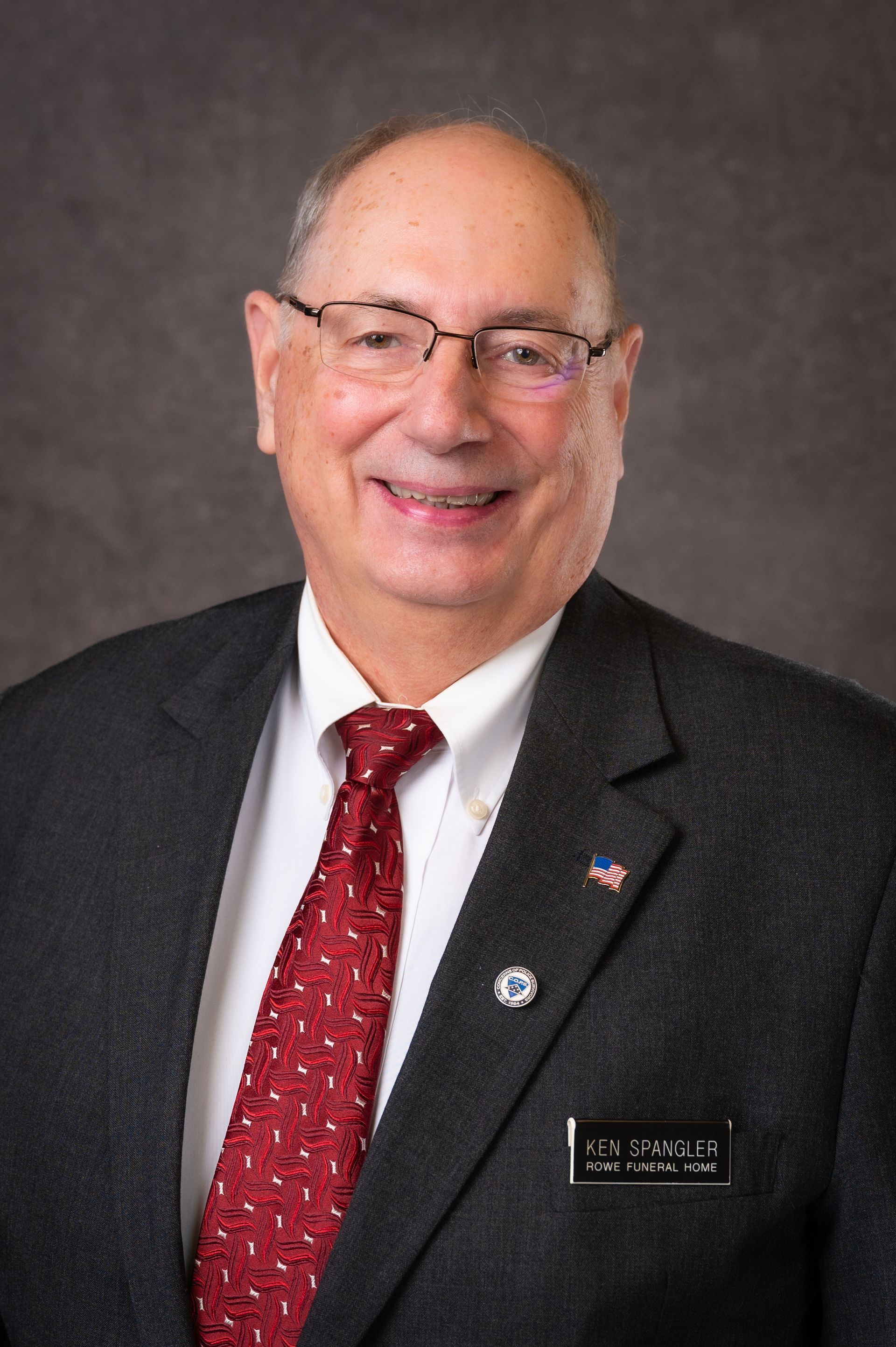 A man in a suit and tie is smiling for the camera.