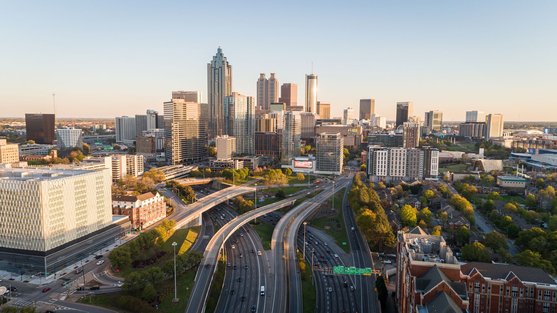 An aerial view of a city skyline with a highway in the foreground.