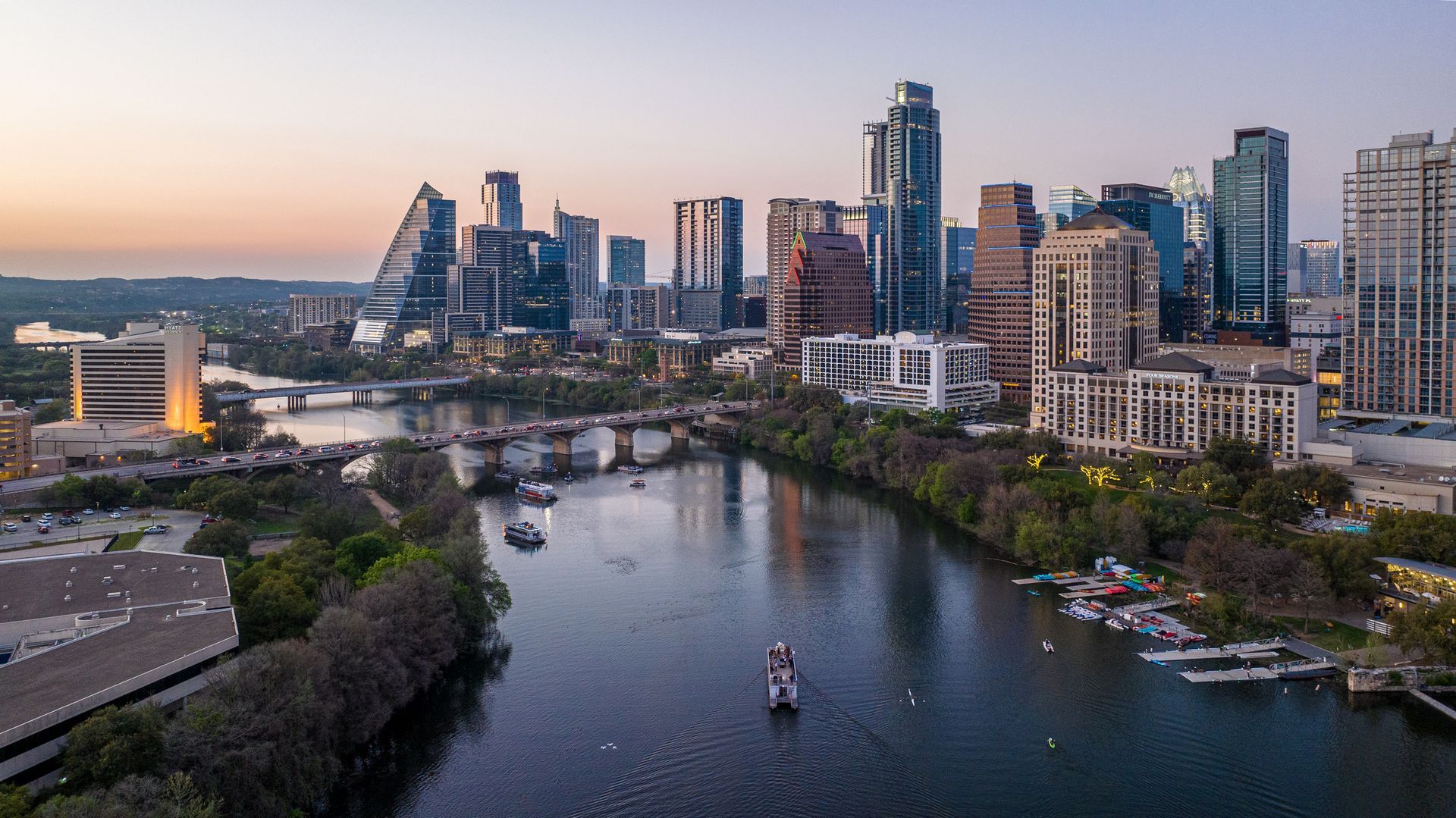 An aerial view of a river with a city skyline in the background.