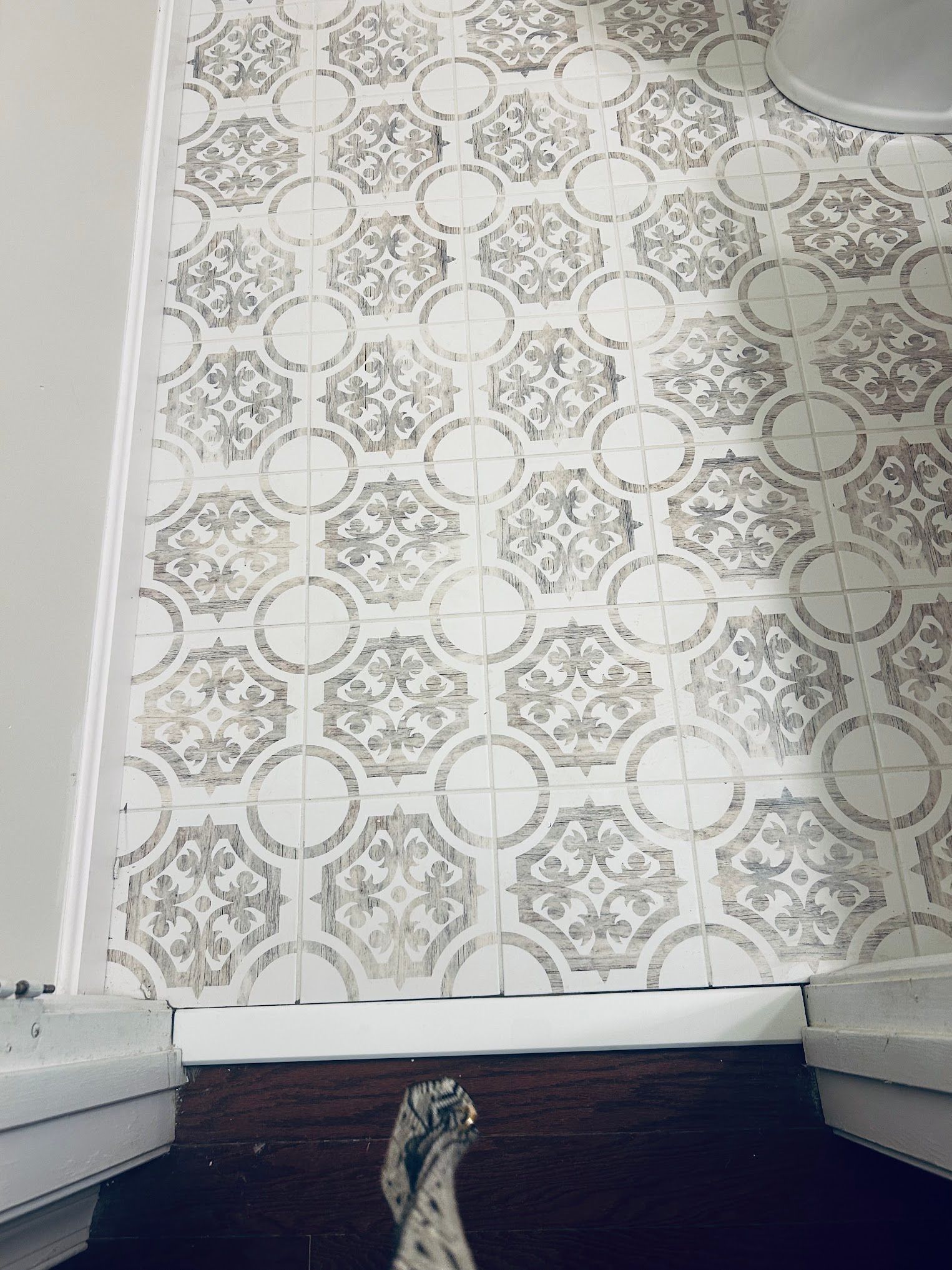 A bathroom with a tiled floor and a toilet.