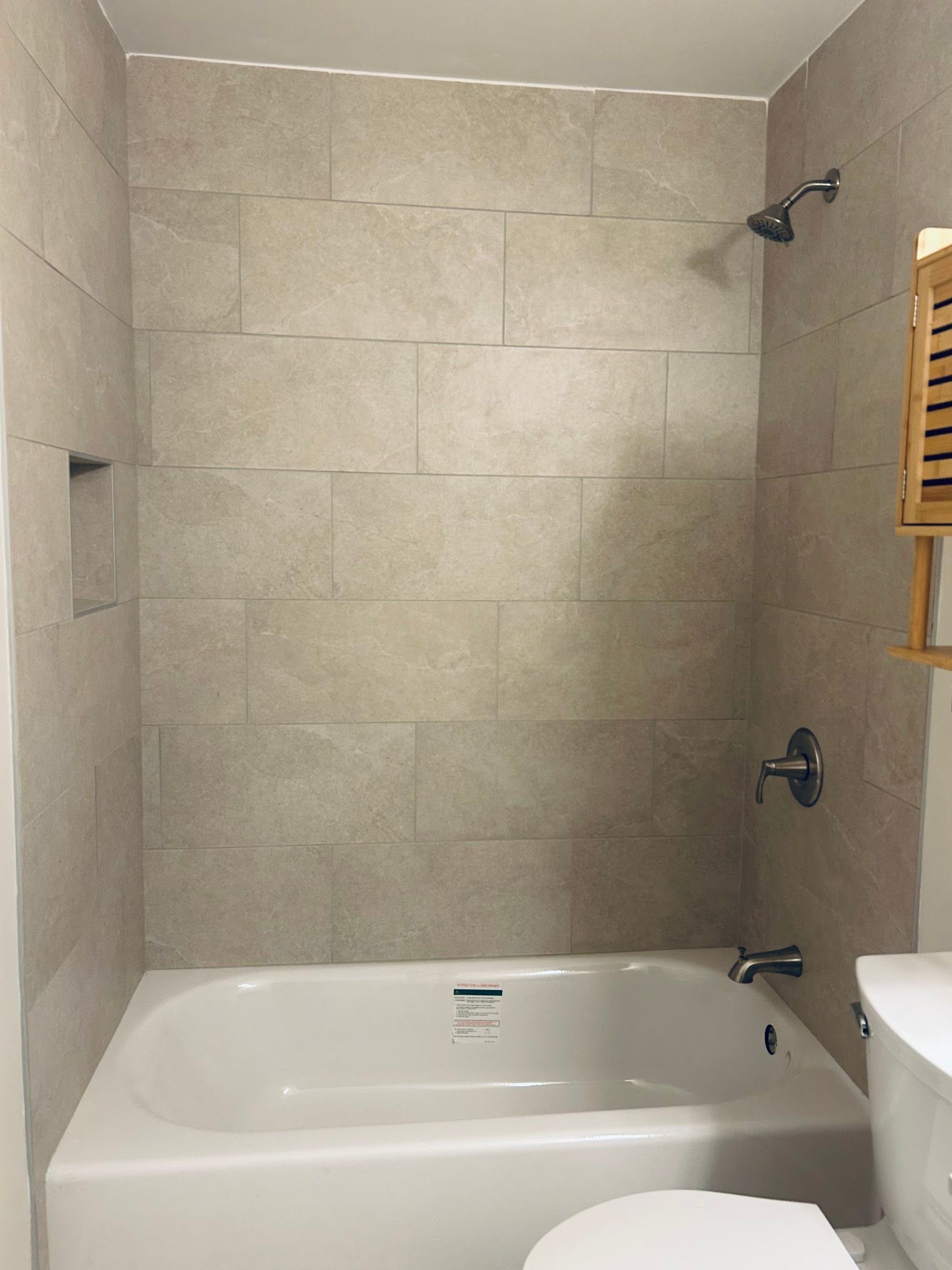 A bathroom with a bathtub , toilet and shower.