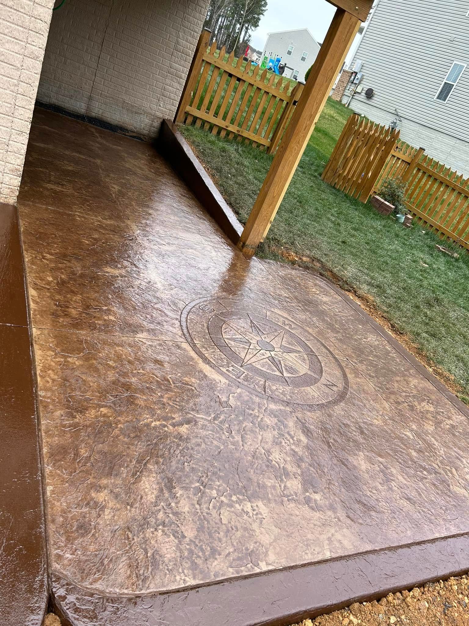 A concrete patio with a wooden fence in the background.