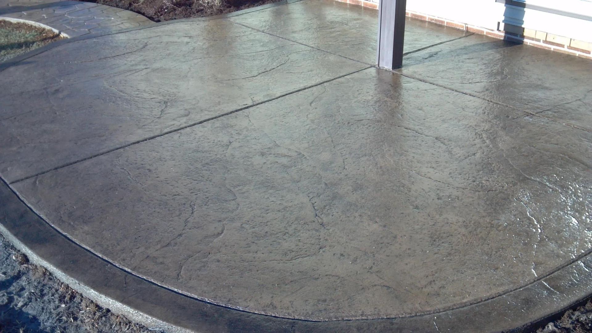 A concrete patio with a fence in the background