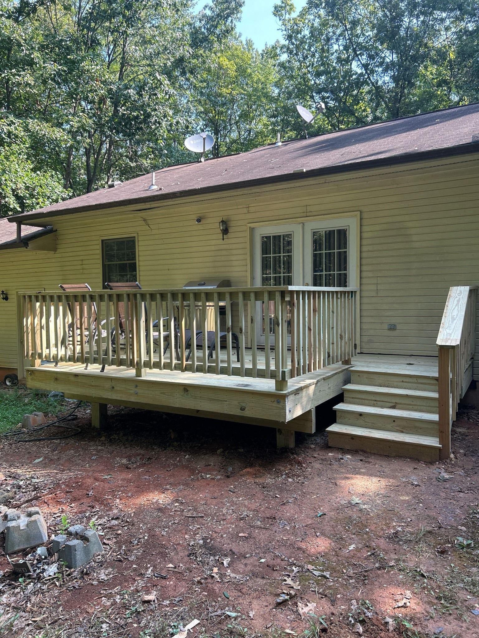 A small house with a wooden deck and stairs.
