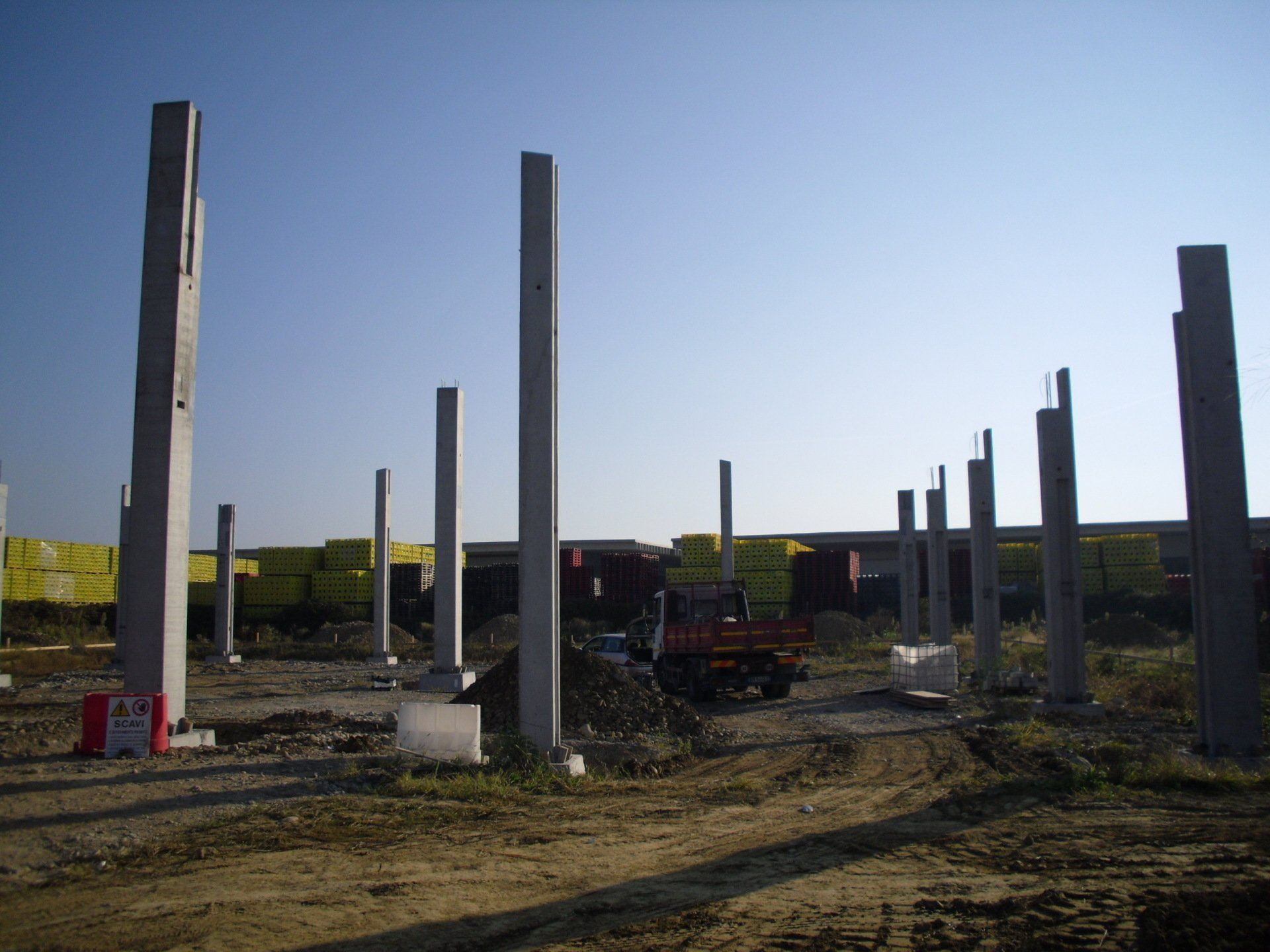 un campo pieno di colonne di cemento e un camion rosso .