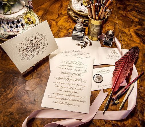 A feather pen is sitting on top of a piece of paper on a table.