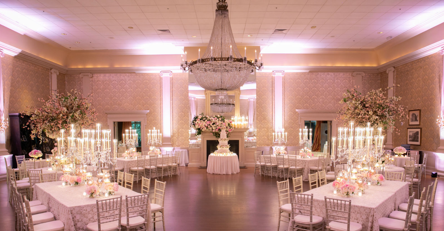 A large room filled with tables and chairs and a chandelier.