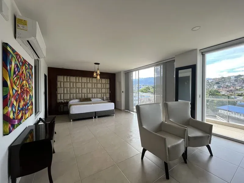 uite moderna y amplia en Hotel Andinos Plaza Florencia Caquetá, con cama king size, aire acondicionado y ventanales panorámicos con vista a la ciudad y montañas, ideal para viajes de descanso o negocios en Colombia