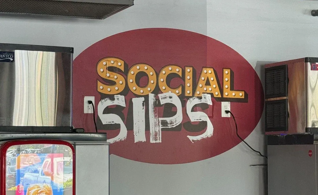 Red oval wall graphic with the text “Social Sips”