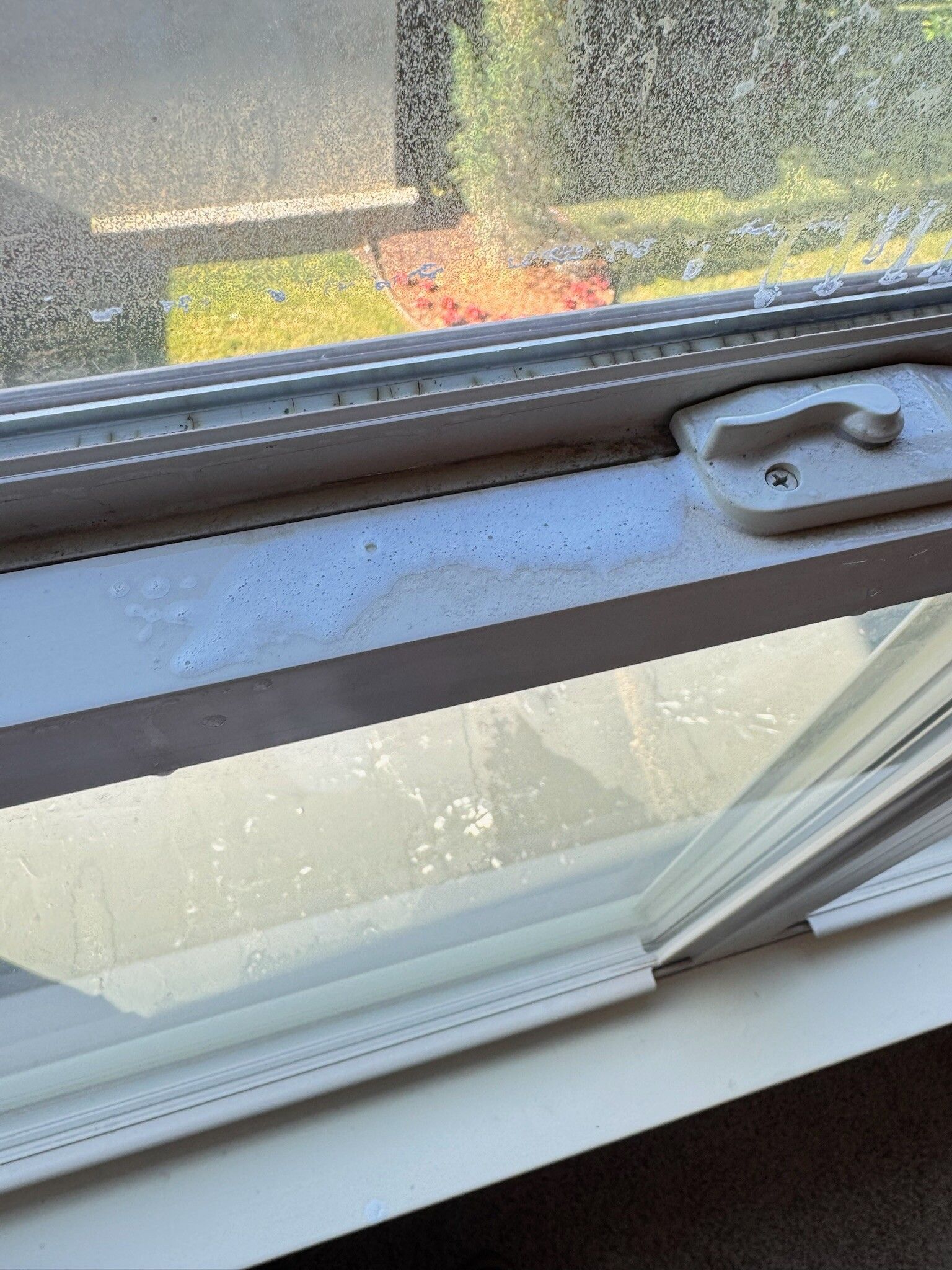 White window frame with a partially open window; exterior view.