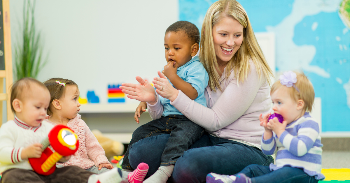 A woman is sitting on the floor with three babies.