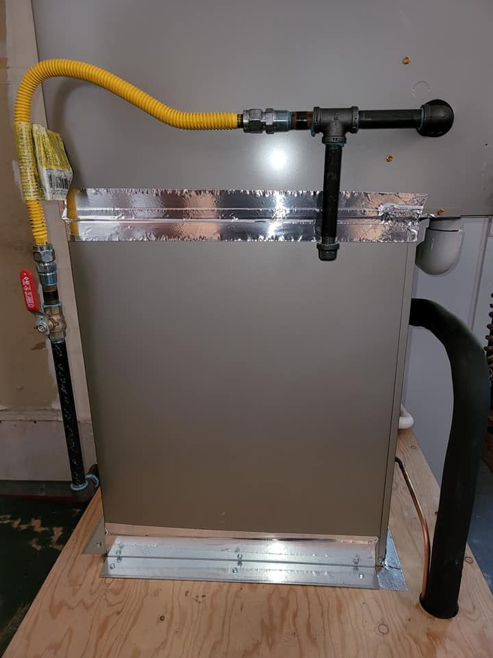 A gas hose is attached to a metal box on a wooden table.