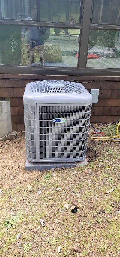 A large air conditioner is sitting on the ground in front of a window.