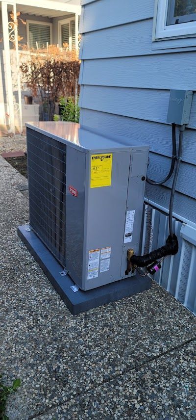 An air conditioner is sitting on the side of a house.