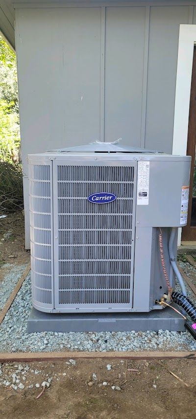 A carrier air conditioner is sitting outside of a building.