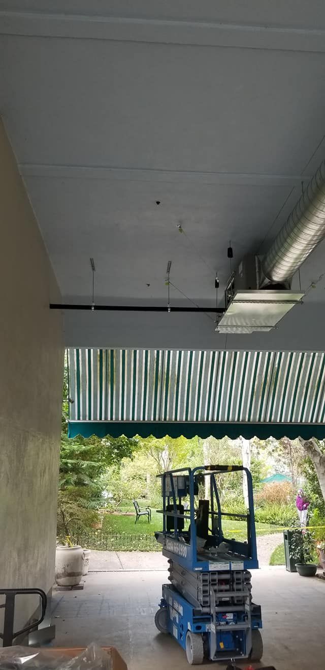A man is riding a scissor lift in a garage.