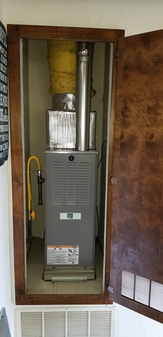 An air conditioner is sitting inside of a closet with the door open.