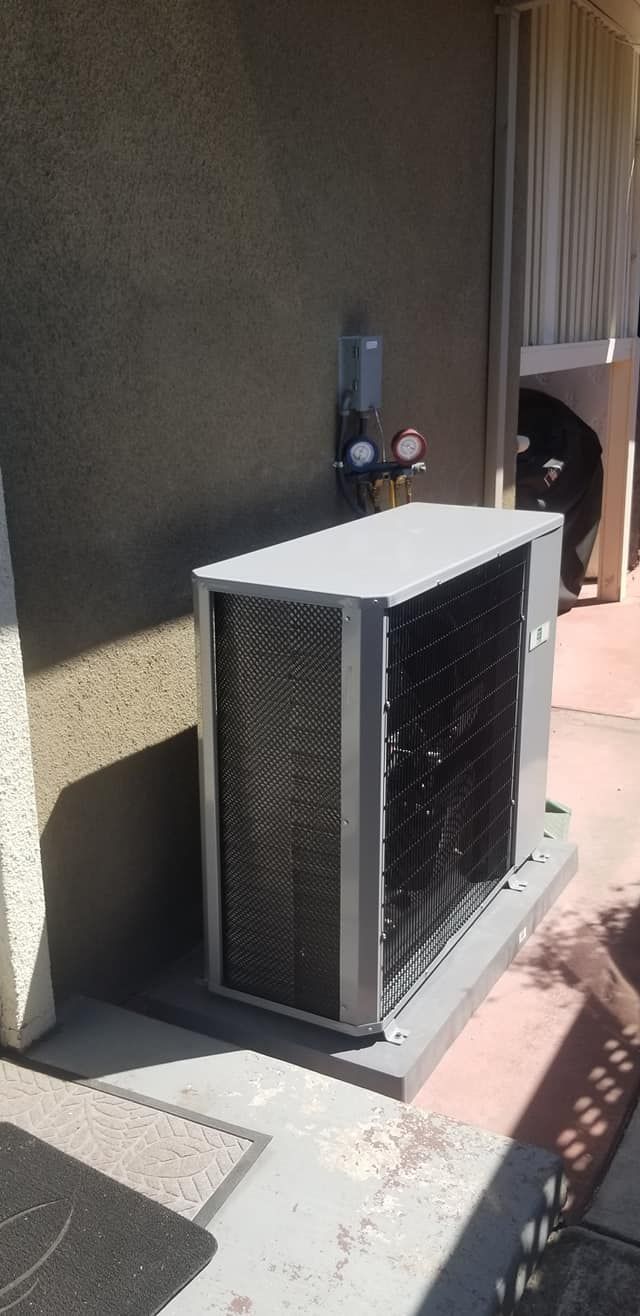 A large air conditioner is sitting on the side of a building.