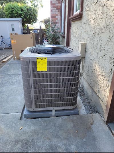 A gray air conditioner with a yellow tag on it