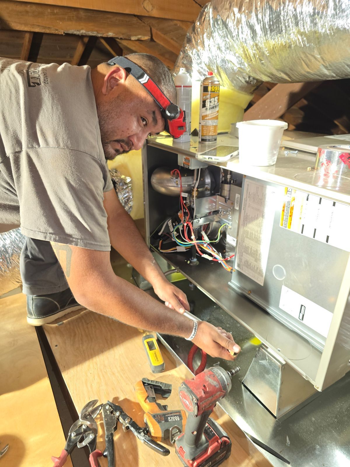 A man wearing white gloves is working on a boiler.