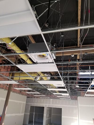 A ceiling with a lot of wires hanging from it.