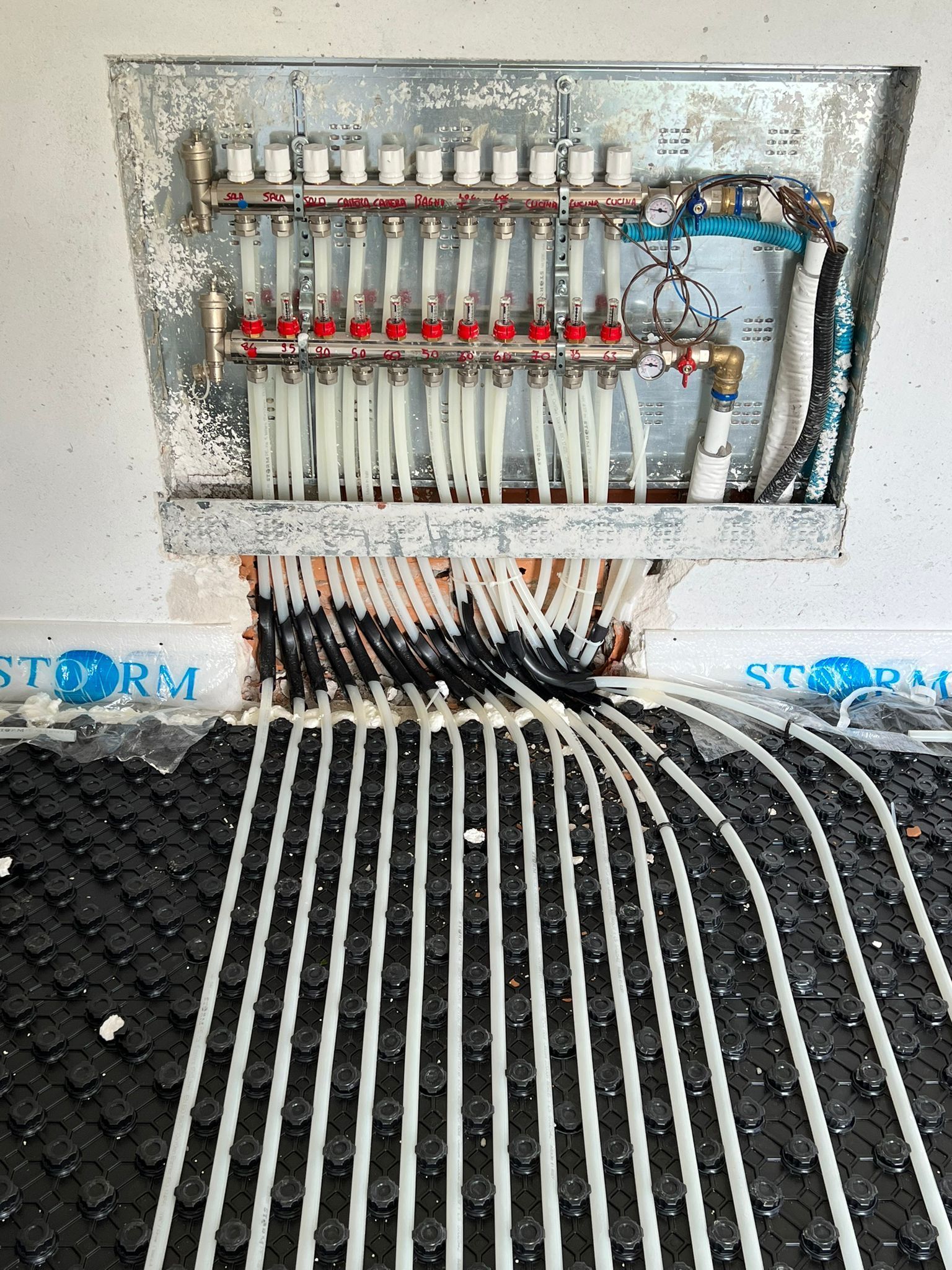 un sacco di tubi attaccati a un muro