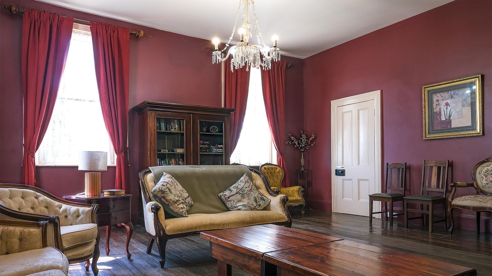 Red sitting room in the main house with antique furniture