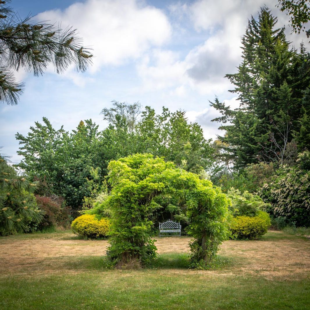 Part of the garden at the fitzpatricks inn with an archway and garden seat