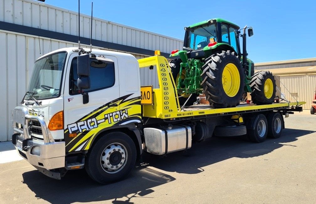 Tow Truck Carries a Green Tractor on Its Flatbed— Pro-Tow Toowoomba in Wilsonton, QLD