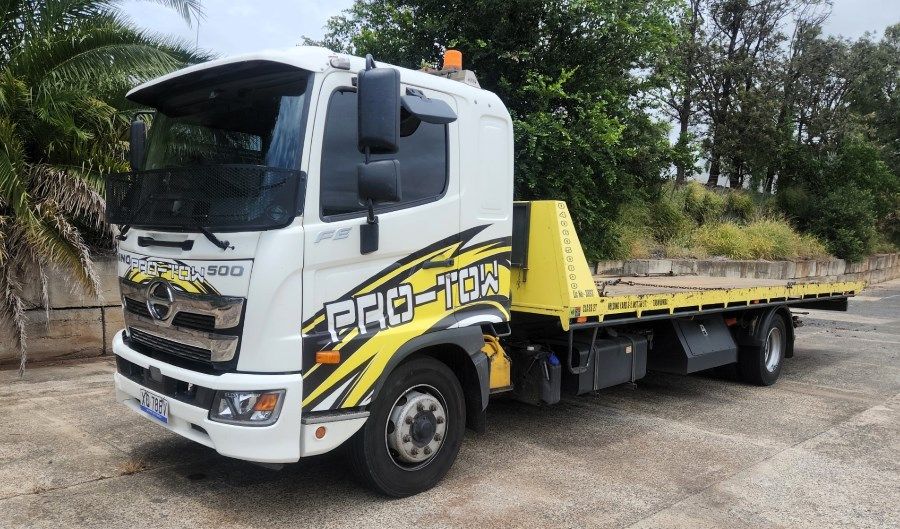 A White and Yellow Tow Truck is Parked in a Parking Lot — Pro-Tow Toowoomba in Wilsonton, QLD